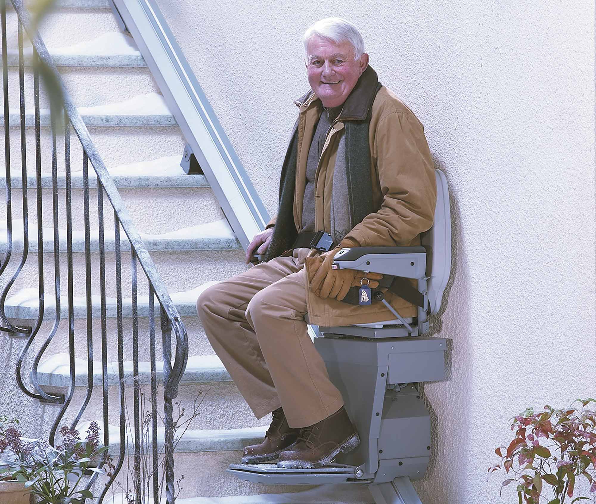 man sitting on outside stiarlift