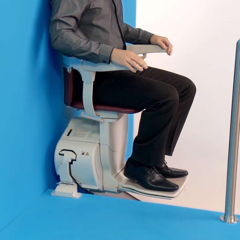 close up of stairlift seat with person sitting in it