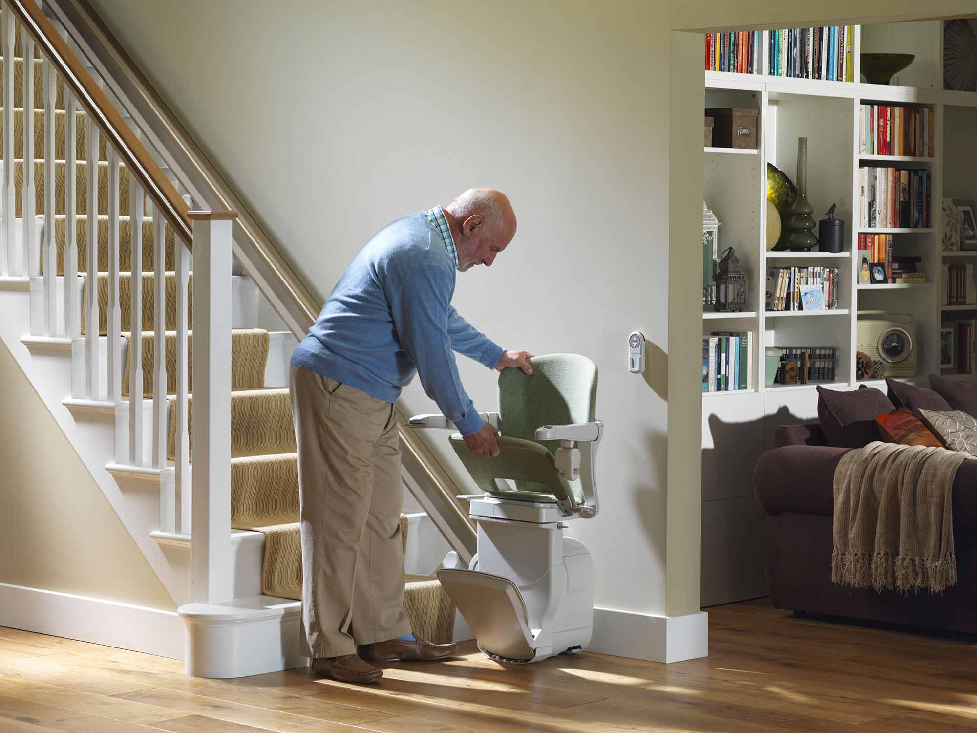 man folding up stairlift to be out of way