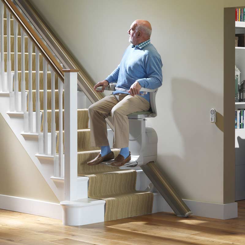 man riding up stairlift at home